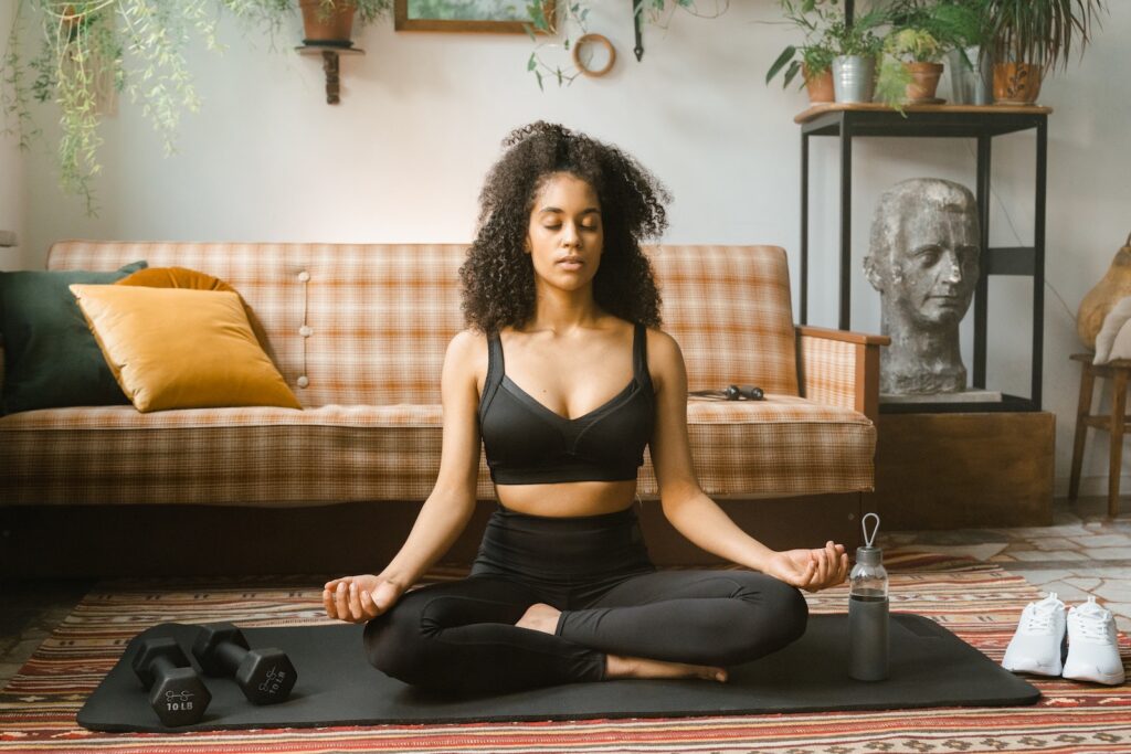 Woman in Black Activewear Meditating Indoors
